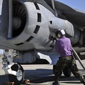 Aviation fuel technician attaches a fuel line to an AV-8B Harrier