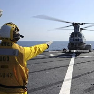 Boatswainas Mate directs a CH-46 Sea Knight helicopter aboard USS Germantown