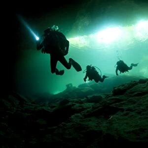 Cavern divers enter cenote system in Mexicos Yucatan Peninsula