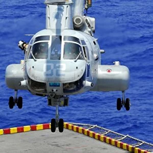 A CH-46E Sea Knight helicopter prepares to land on the flight deck of USS Peleliu