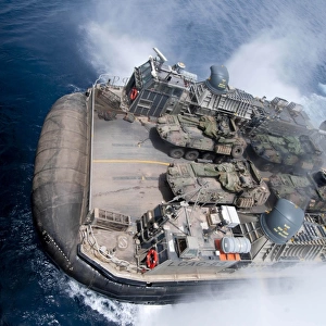 A landing craft air cushion enters teh well deck of USS Iwo Jima