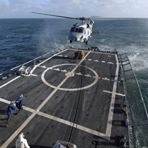 U. S. Navy sailors prepare to attach a pallet of supplies to an SH-60B Seahawk helicopter