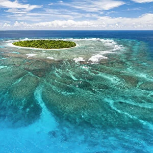 Aerial panorama of Fangasito Island with the underwater coral reef clearly visible, Vava'u island group, Kingdom of Tonga, South Pacific, with Fonua'one'one island visible in the background. September 2019