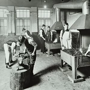 Boys using forges in a blacksmiths shop, Beaufoy Institute, London, 1911