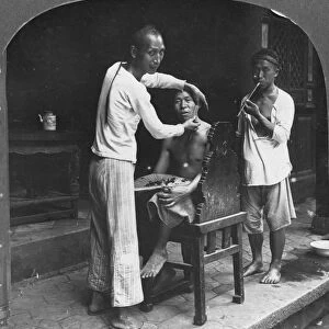 A Chinese barber at Bhamo, Burma, 1908. Artist: Stereo Travel Co