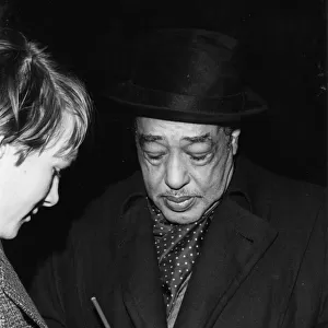 Duke Ellington signing his autograph, c1962. Creator: Brian Foskett