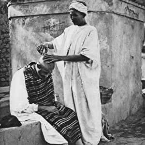 A street barber and his client, Algeria, Africa, 1922. Artist: Donald McLeish