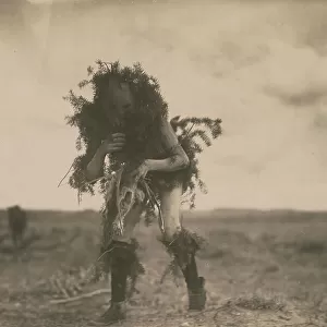 Yeibichai, the beggar, Tonenili-Navajo Indian, dressed in spruce branches, 1904, c1905. Creator: Edward Sheriff Curtis