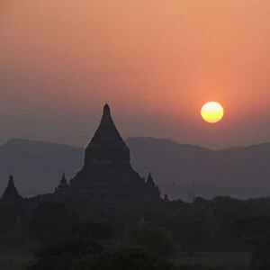 Burma (Myanmar), Bagan, Silhouetted temples and sunball at sunset