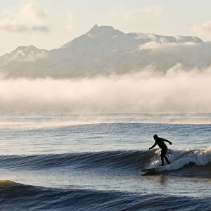 Man Surfing In Moring Near Homer Kachemak Bay W / Kenai Mountains Kenai Peninsula Alaska Winter