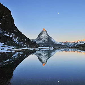 Matterhorn reflected in Lake Riffelsee at Sunrise with Moon, Zermatt, Alps, Valais, Switzerland