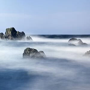 Mist Surrounding Big Rocks In The Water; Northumberland, England