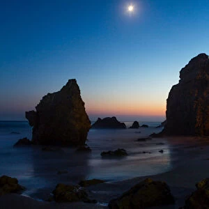 The moon over El Matador state beach at night, Malibu, California, USA