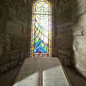 An Open Bible And A Stained Glass Window In St. Marys Church; Holystone, Northumberland, England