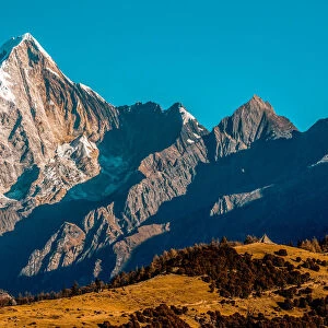 Rugged mountainous terrain of Mount Siguniang under a bright blue sky, Siguniang National Park; Ngawa Prefecture, Sichuan, China