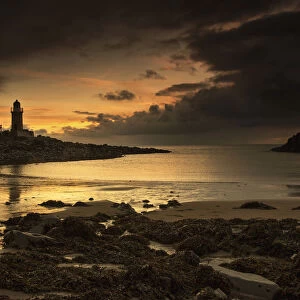 Silhouette of a lighthouse along the coast at sunset; Portpatrick dumfries and galloway scotland