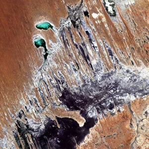 Simpson Desert, Australia, True Colour Satellite Image. True colour satellite image of the Simpson Desert in the Australian Outback. The sand dunes are coloured in red because of iron oxyd. The green areas are lakes and oueds. East is a calcareous plateau. Image taken on 29 July 1992 using LANDSAT data
