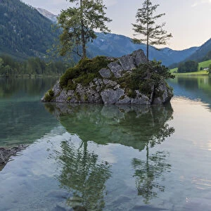 Small rock island with trees on Lake Hintersee with mountains at dawn at Ramsau in the Berchtesgaden National Park in Upper Bavaria, Bavaria, Germany