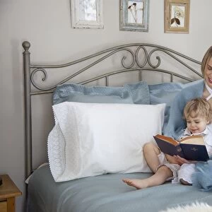 Toddler And Mother In Bed Reading; Jordan, Ontario, Canada