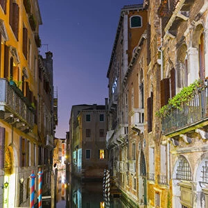 Turquoise Water In A Narrow Canal Between Buildings At Dusk; Venice, Veneto, Italy
