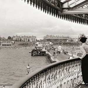 Two women look down on Clacton pier at Clacton-on-Sea, Essex, England towards the end of the 19th century. After a print by an unknown photographer
