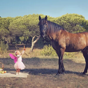 Young Girl With Pink Ferry Wings And A Brown Horse; Tarifa, Cadiz, Andalusia, Spain