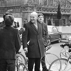 Actor Telly Savalas, surrounded by young fans with bikes