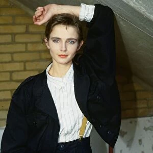 Annabel Giles model TV presenter wearing black jacket white shirt yellow braces arm above