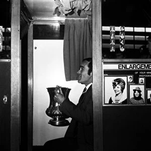 Chelsea captain Ron Harris sits in the Photo booth on Piccadilly station with the FA Cup