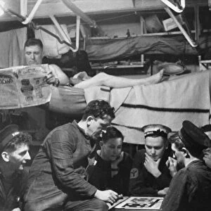 The crew of a Royal Navy escort destroyer enjoying a rest period below decks between