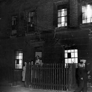 A family posing outside their home in Cab; e Street, Mile End London during a dim-out