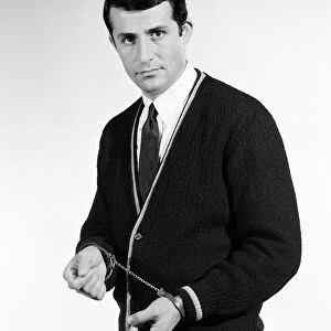 Handcuffs feature. Model Henry Fern in cardigan wearing handcuffs. Circa 1964