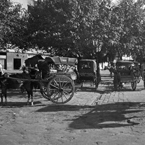 Horse - drawn taxis seen here waiting outside Poonah railway station. April 1959