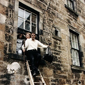 Iain McColl actor with family climbing out window down ladders