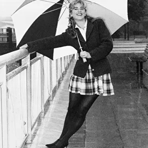 Imogen Stubbs Actress holding up Umbrella and leaning back while holding on to railing
