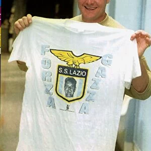 Lazio footballer Paul Gascoigne holds a club t shirt after a training session 26th