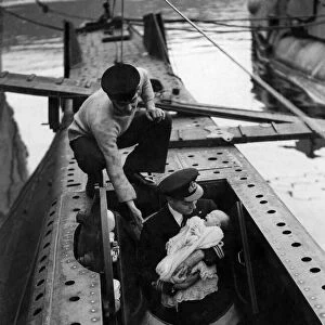 Lieutenant Commander HRB Newton entering in the submarine torpedo space with his son Max