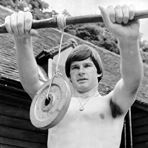 Nick Faldo Golf stands bare chested as he exercises his wrists by holding a weight