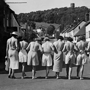 Putting their backs into their holiday. A group pf women walking down the street wearing