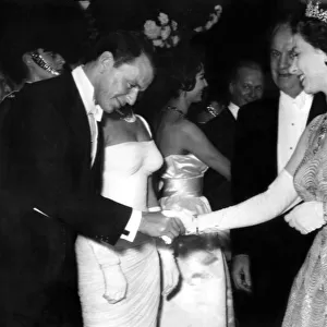 Queen Elizabeth II, Frank Sinatra bows as he meets the Queen at the premiere of the film
