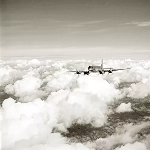 RAF Hastings aircraft flies through cloud cover far above the landscape below. Circa 1950
