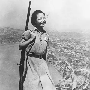 A smiling young girl, who is a soldier in the Chinese army during the Second World War