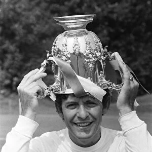 Tottenham Hotspur footballer Alan Mullery poses with the League Cup trophy upside down