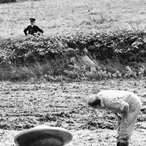 UFO being inspected by farmer Jennings after landing in his field whilst a police officer