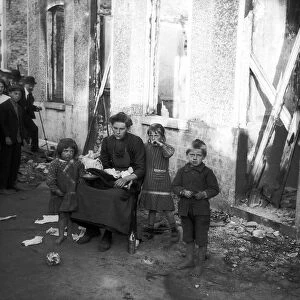 World War One. Widow and three children outside ruined home in Melle