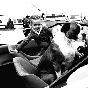 A young girl and her dog try out a speedboat at the Whitley Bay Motor Show. 18 / 07 / 80
