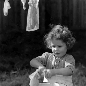 Young girl wringing out the washing. c. 1945 P044481