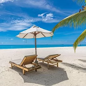 Beach umbrella and chairs for summer couple vacation, holiday, honeymoon travel destination. Luxury beach landscape sea view. Tropical island resort