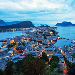 Night scene of Alesund port town on western coast of Norway. Place where the ocean meet the mountains