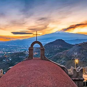 Taormina, Sicily, Italy with the ancient Church of San Biagio and Mt. Etna at dusk